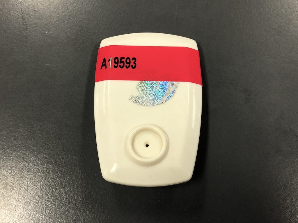 Red non-transfer tamper evident label on plastic device