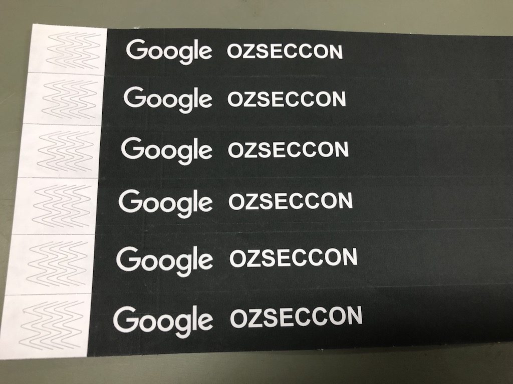 Black tamper evident wristbands with white writing saying google ozseccon