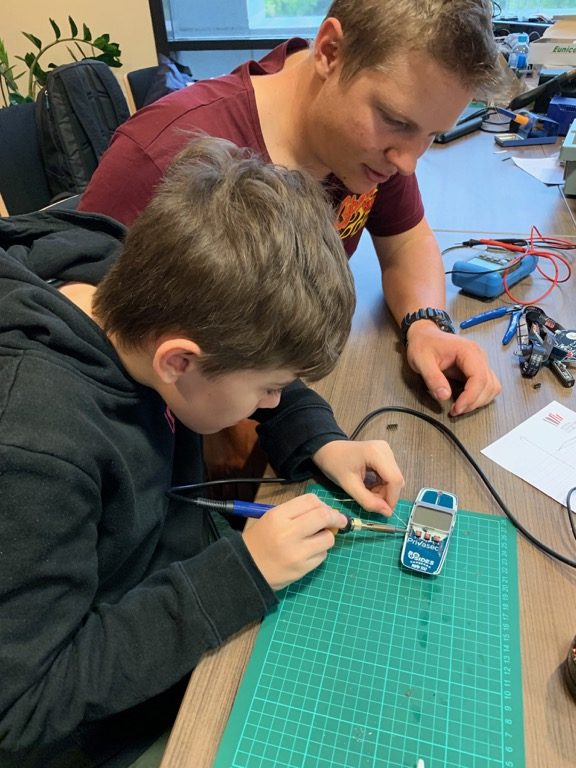 Soldering headers to the BSides Canberra 2019 badge with help from Tim