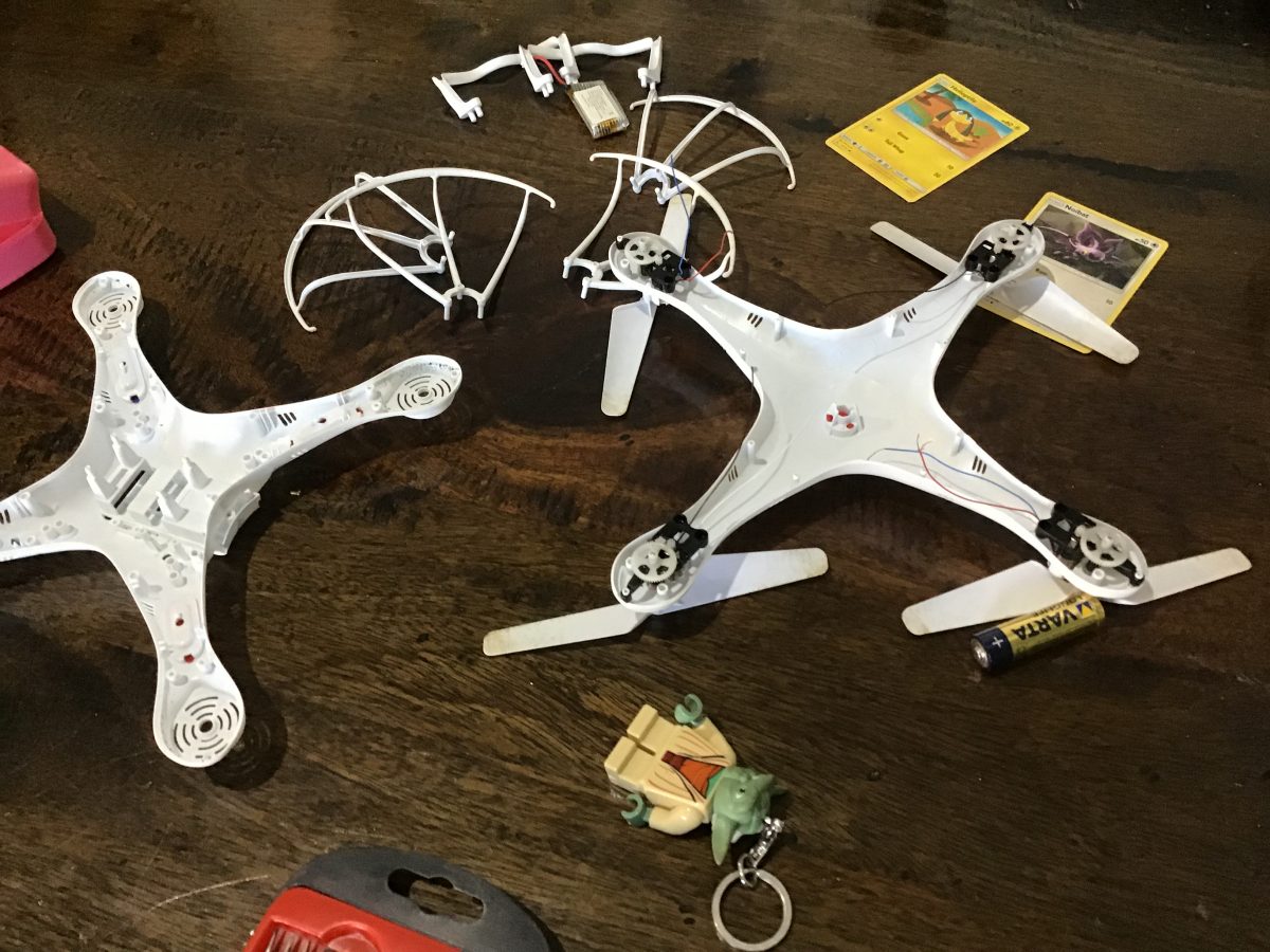 white drone in 2 seprate pictures with yoda torch and battery next to it