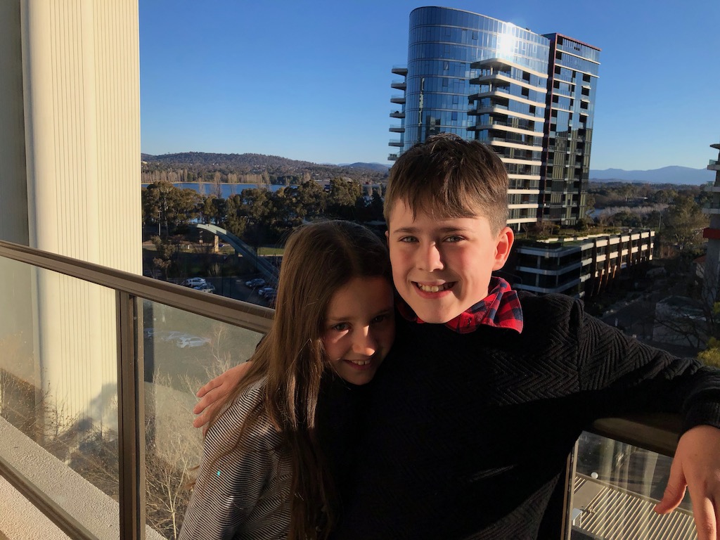 Mos and Boo standing on hotel balcony overlooking Canberra