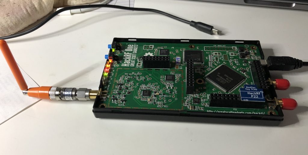 Photo of a HackRF module with an orange antenna