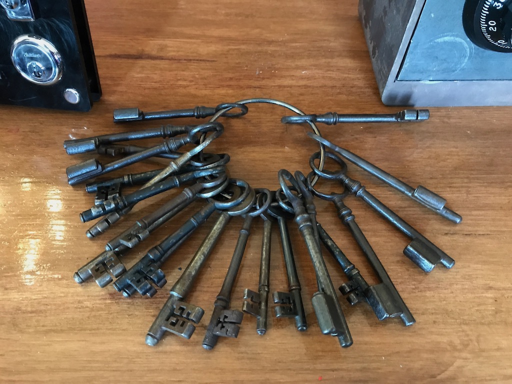 ring of old keys with safe and other practice lock in background
