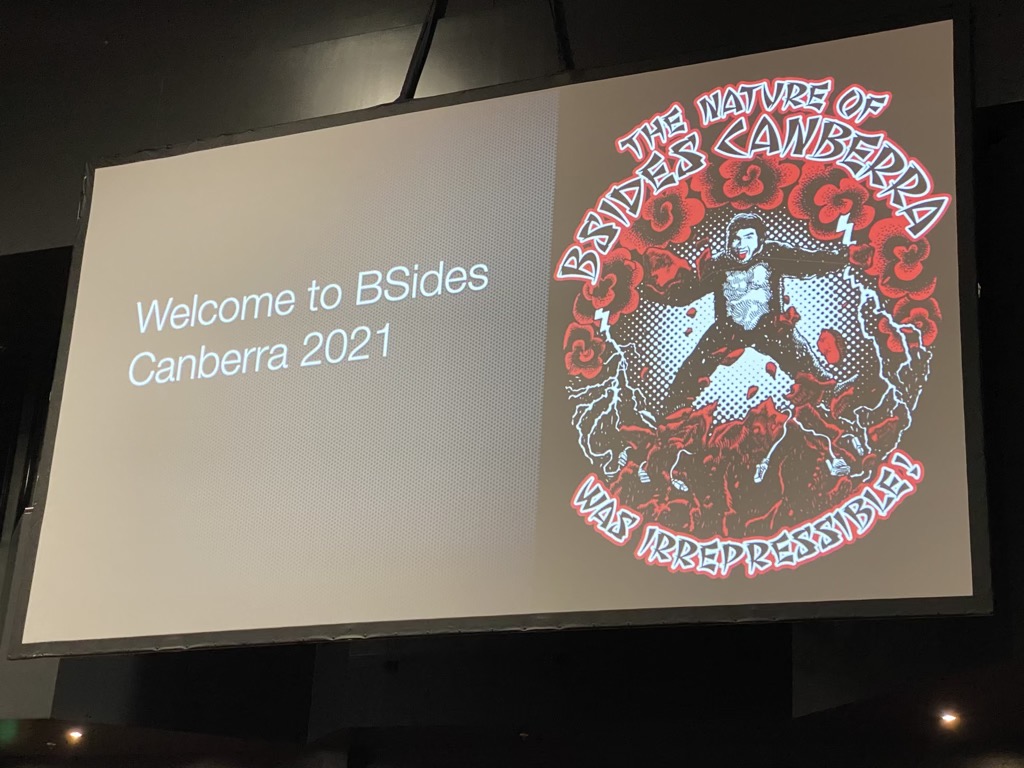 Screen showing BSides CBR 2021 intro in auditorium